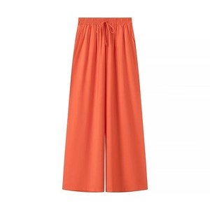 Détail d'un pantalon large orange avec taille élastique et cordons de serrage réglables