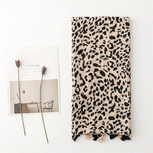 Detail of leopard print scarf with pink fringe tassels next to a lifestyle magazine