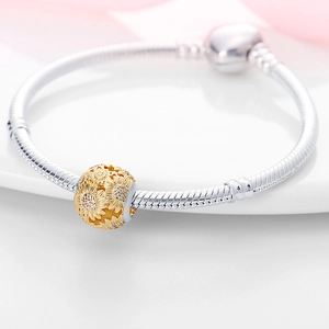 Detalle macro de pulsera de plata con cadena de serpiente y cuenta de girasol dorado