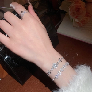 Détail de bracelets étincelants à fleurs et cœurs en zircon avec bague assortie