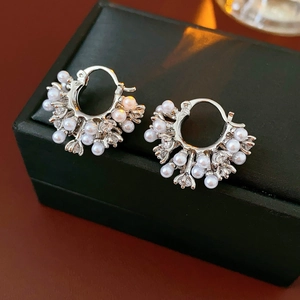 Detail of vintage U-shaped earrings with white pearls and sparkling zircon stones