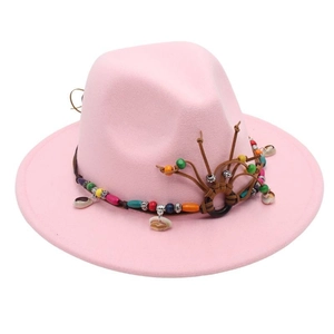 Detailed view of pink wool fedora hat with bohemian woven band and seashell accents