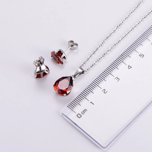 Detailed size comparison of red teardrop zircon necklace and earrings with a ruler