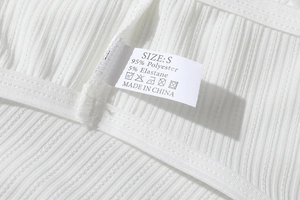 Close-up of white polyester fabric texture and product care label for low-waist thong