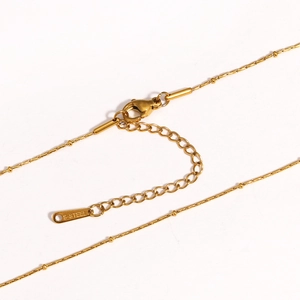 Macro shot of gold-plated stainless steel satellite chain with lobster clasp and S-STEEL tag