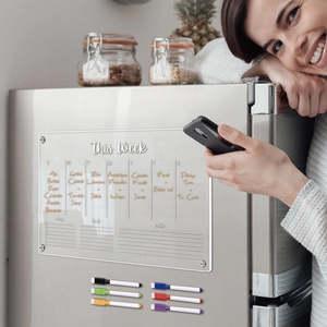 Clear acrylic magnetic weekly planner on fridge with six colorful dry erase markers