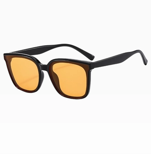 Detail of square black frame sunglasses with vibrant orange lenses for retro style