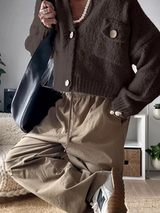 Close-up of a women's dark brown knit cardigan and khaki cargo pants for casual wear