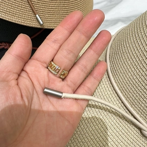 Gros plan d'une bague dorée en forme de lettre avec cristaux et anneau ajustable ouvert