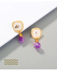 Detailed macro view of purple natural stone earrings with irregular gold frames