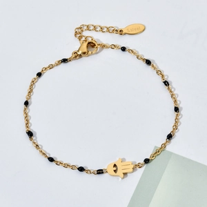Detailed close-up of golden stainless steel Hamsa Hand bracelet with black beads