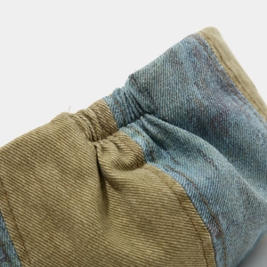 Macro detail of khaki twill and blue washed denim fabric stitching on the octagonal cap