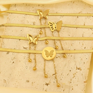 Dettaglio della collana a farfalla dorata con texture in metallo spazzolato e opaco