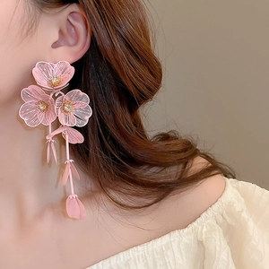 Macro shot of pink floral tassel earrings with mesh petals and zircon accents on a model