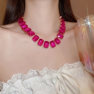 Close-up of luxury rectangular fuchsia gemstone choker necklace on female model