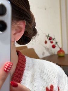 Detailed close-up of a silver teardrop earring with cubic zirconia worn by a model