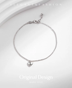 Macro detail of S925 sterling silver ball chain bracelet with polished heart pendant