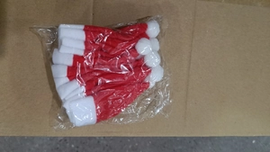 Close-up of mini red and white non-woven Christmas hats used for cutlery and bottle decor