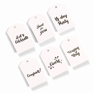 Detailed view of six white paper gift tags with festive English greeting typography
