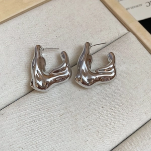 Macro shot of silver irregular lava earrings with organic shape and high-mirror finish