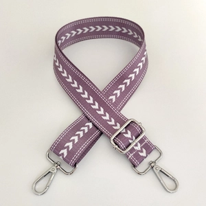 Detail of purple and white chevron nylon bag strap with silver metal lobster clasps