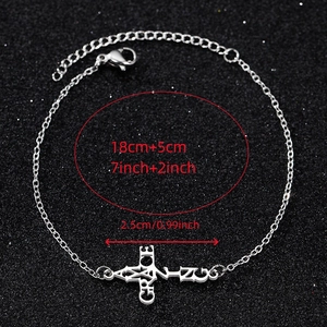 Macro shot of silver stainless steel chain bracelet with a carved GRACE cross charm