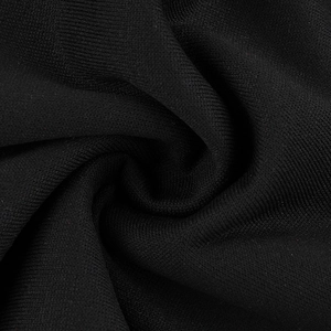 Close-up of black knitted fabric showing fine texture and soft drape of the sweatshirt