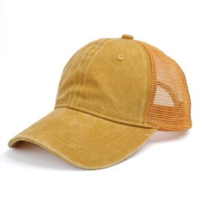 Detail of vintage washed mustard yellow trucker hat with breathable mesh back and curved brim