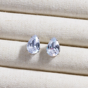 Macro shot of 6-12mm pear-shaped white zircon earrings in a four-claw silver setting