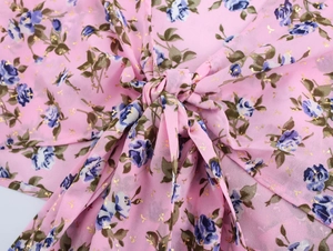 Vista dettagliata del top bohémien rosa con stampe floreali e design con nodo