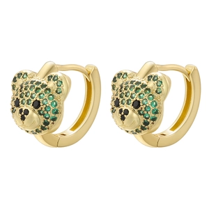 Macro detail of golden teddy bear hoop earrings with green sparkling zircon pavé setting