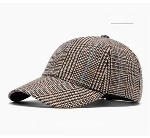 Close-up of khaki houndstooth baseball cap showing vintage plaid pattern and stitching