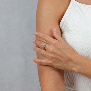 Close-up of gold-plated stainless steel ring with a circular cluster of blue stones