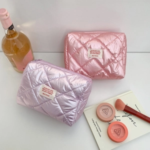 Quilted metallic makeup bags in pink and purple with diamond pattern and woven labels