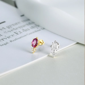 Macro detail of S925 silver flower earrings with red and white diamond-set gemstones