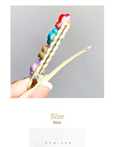 Detail view of colorful floral hair clip with metal duckbill teeth and spring mechanism
