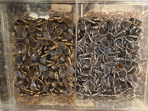 Bulk display of teardrop gemstone pendants in gold and silver metal bezel frames