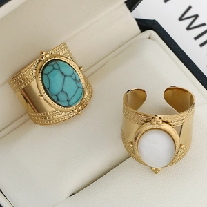 Detail of adjustable gold stainless steel wide rings with turquoise and opal stones