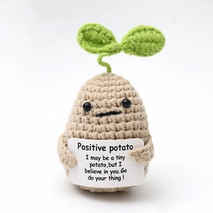 Macro shot of handmade crochet positive potato toy with encouraging English message card