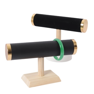 Detail of black velvet jewelry T-bar with gold caps and solid wood stand for watches