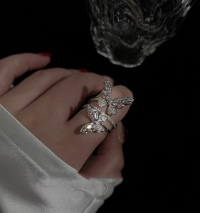 Close-up of double butterfly silver ring featuring sparkling zircon inlay on hand