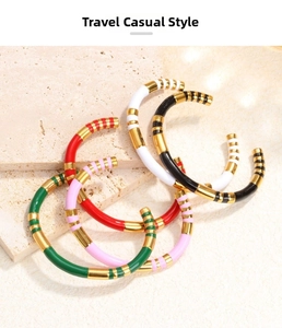 Detail of five-piece enamel stackable C-shaped open bangles with golden stripe finish