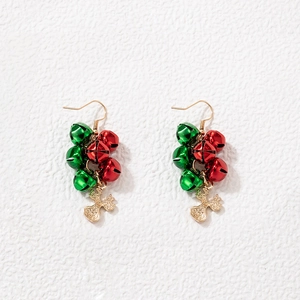 Close-up of festive Christmas earrings with red and green bells and gold reindeer charms
