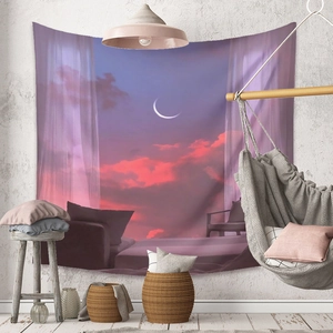 Detail of bohemian tapestry with crescent moon landscape and sunset hanging in a cozy room