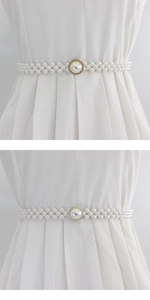 Détail d'une ceinture élastique en perles avec boucle fleurie sur une robe plissée
