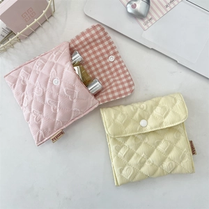 Dettaglio di pochette trapuntate a cuore con fodera a scacchi e chiusura a pressione