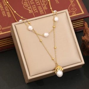 Elegant double-layered gold necklace with irregular pearls and dripping metal pendant