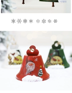 Close-up of hand-painted iron Christmas bell ornaments with Santa Claus and tree patterns