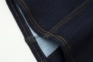 Gros plan sur tissu denim bleu foncé avec doubles coutures orange de haute qualité