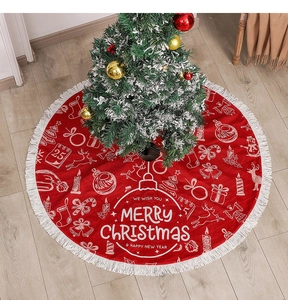 Detail of red Christmas tree skirt with white fringe and festive holiday patterns